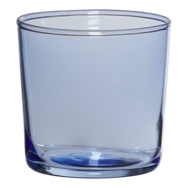 An Anchor Hocking clear rocks glass with a blue rim.