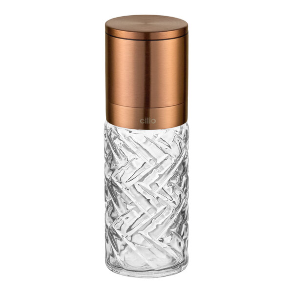 A glass salt or pepper mill with a copper finish top.