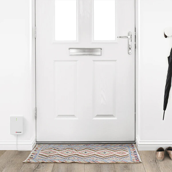 A white door with a Bellman & Symfon contact mat on the floor.