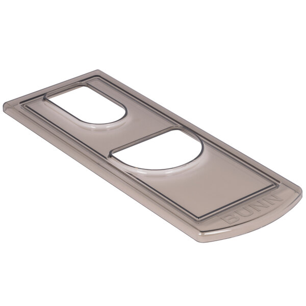 A rectangular metal lid with a small hole in it.