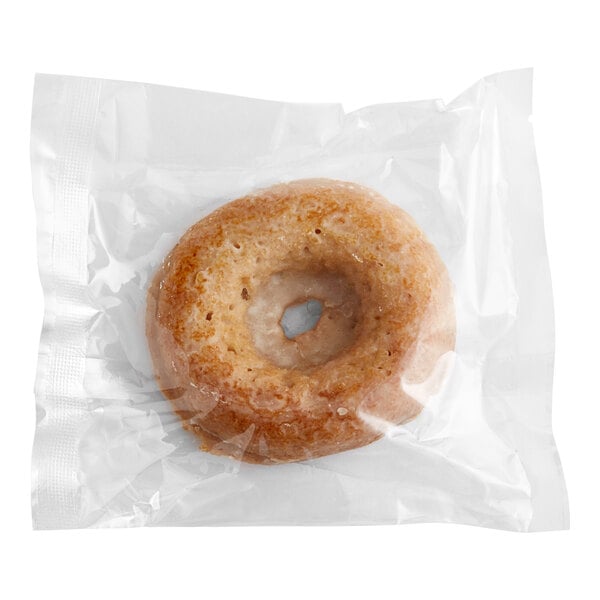 A Southern Roots vegan vanilla glazed cake donut in a plastic bag.