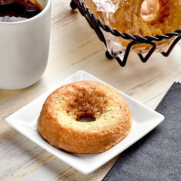 An individually wrapped Southern Roots vegan vanilla glazed cake donut on a plate.