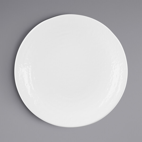 A white Elite Global Solutions round melamine plate with a rim on a gray surface.