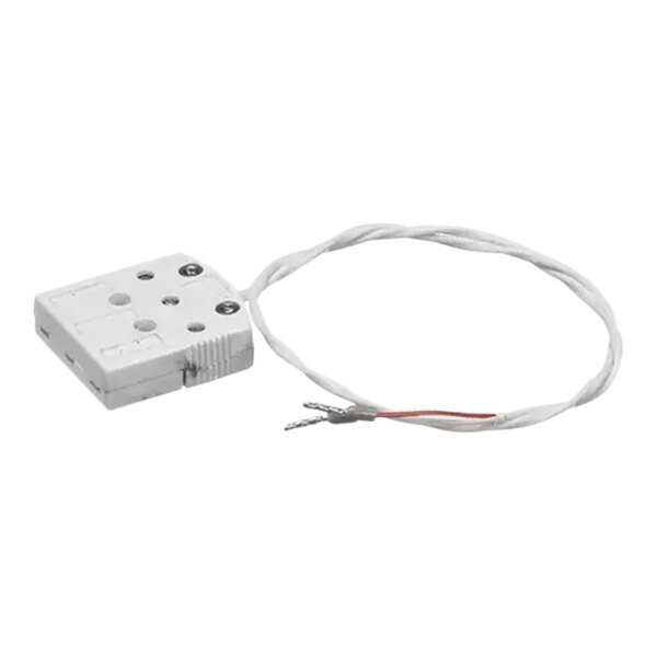 A white rectangular electronic device with a white and red wire attached.
