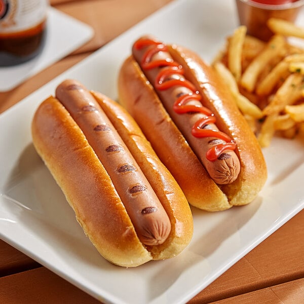 A plate with two Impossible Beef Hot Dogs with ketchup and fries.