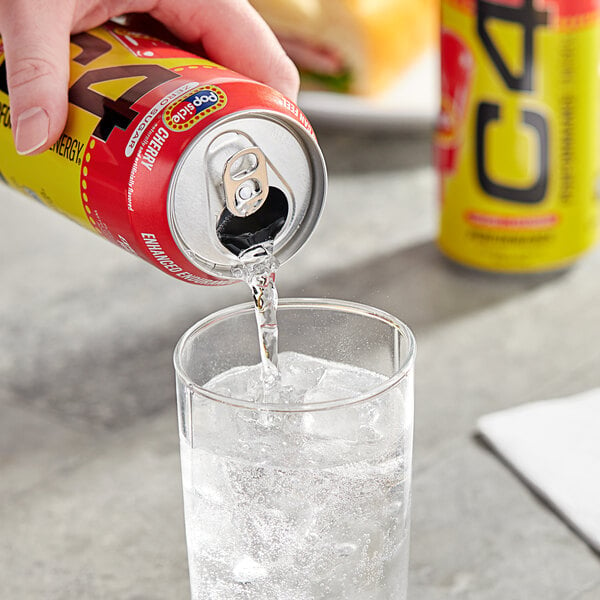 A hand pouring C4 Energy Cherry Popsicle into a glass of ice.