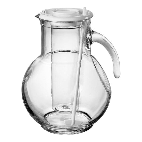 A clear glass pitcher with a handle and an ice core and white straw inside.
