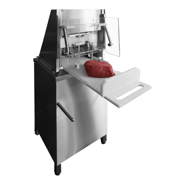 A piece of meat being processed on a commercial meat tenderizer machine.