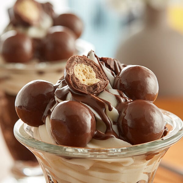 A close up of Albanese triple-dipped milk chocolate malt ball.