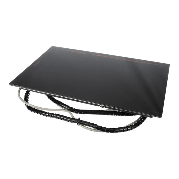 A black rectangular object with wires on a table.