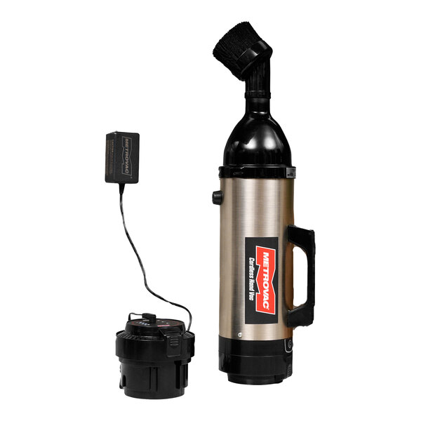 A MetroVac stainless steel handheld cordless vacuum cleaner with a battery and charger.