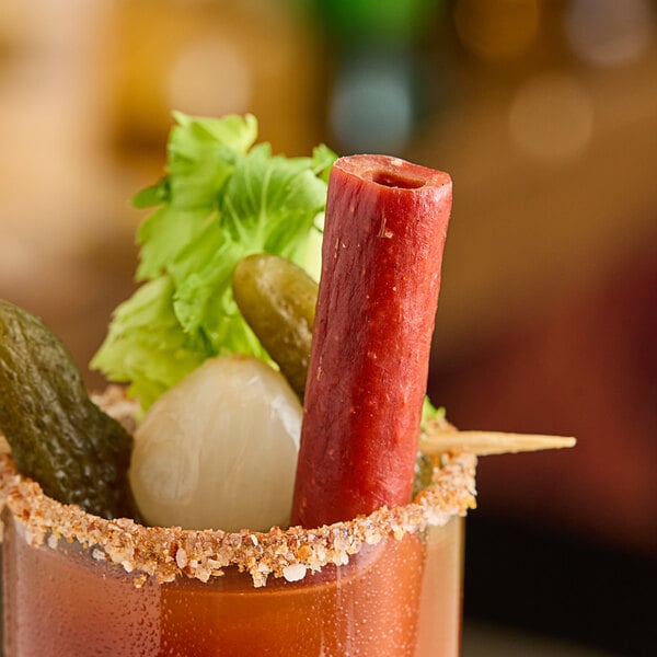 A bloody drink with a Demitri's Pepperoni Straw on a table.