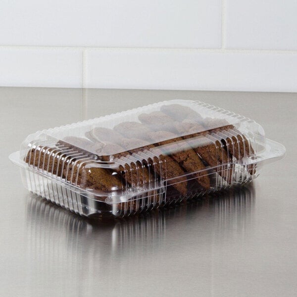 A Dart plastic container of cookies on a bakery counter.