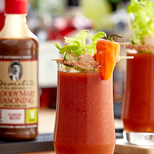 A glass of Demitri's Vegan Classic Bloody Mary with a straw and an orange slice on the rim.