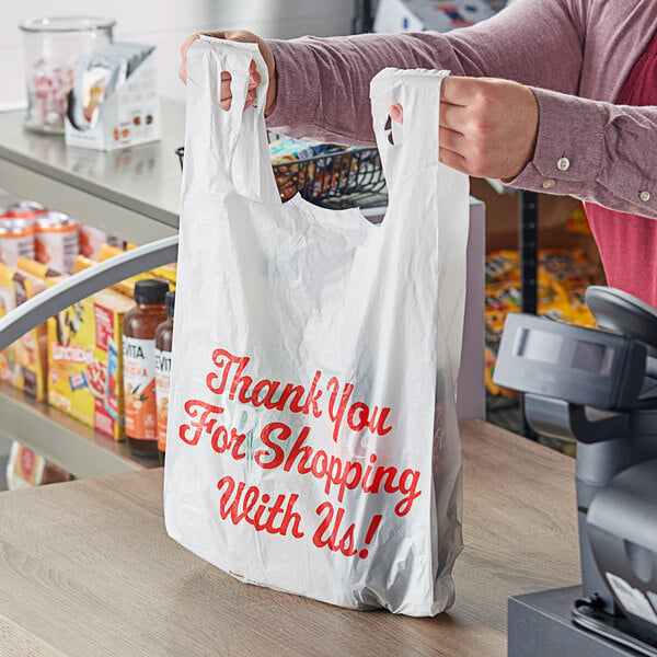 A person holding a white plastic Source Direct Inc. thank you bag.