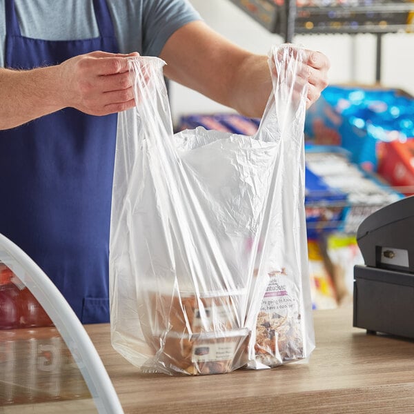 A person holding a Source Direct plastic T-shirt bag.