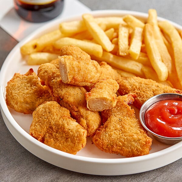 A plate of PAOW! Plant-Based Chick'n tenders and french fries with ketchup.