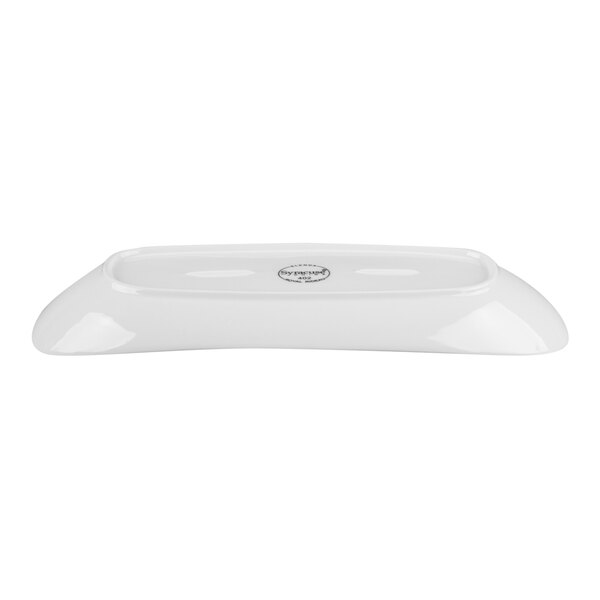A white, oval-shaped porcelain plate shown from a side angle with a glossy finish and a label on the bottom.