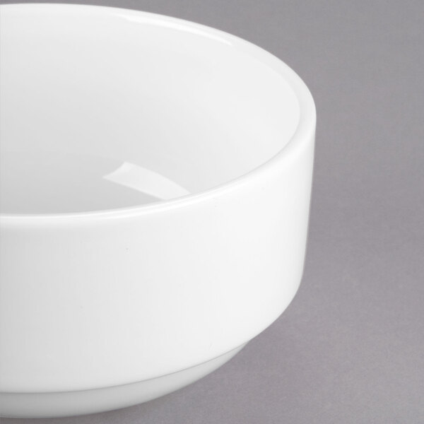 A Libbey Royal Rideau white porcelain bouillon bowl with a white rim on a gray surface.