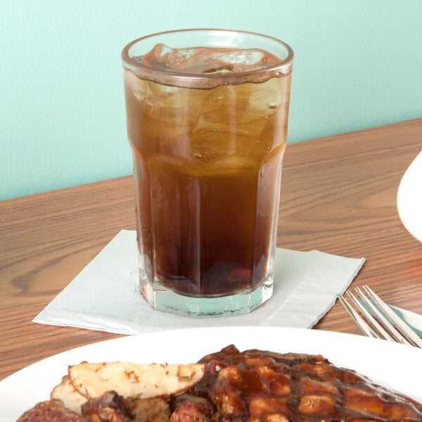 A plate of food and a Libbey Gibraltar beverage glass filled with ice.