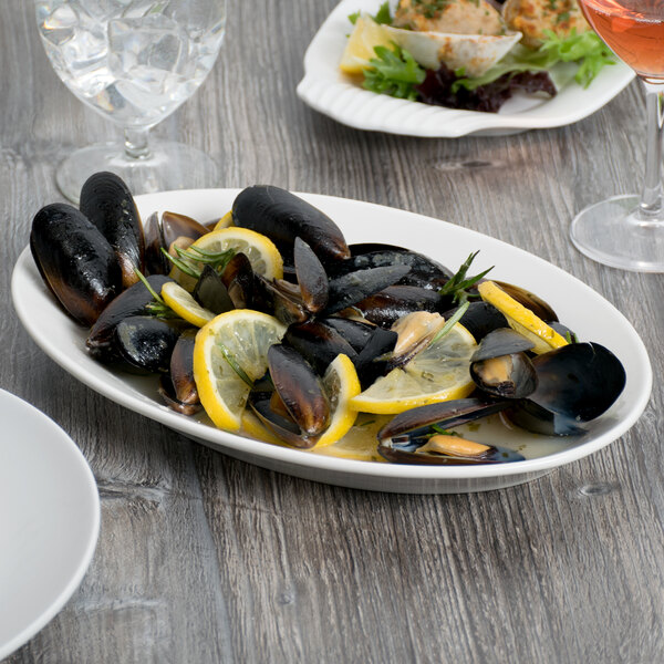 A white Libbey oval platter with mussels and lemons.