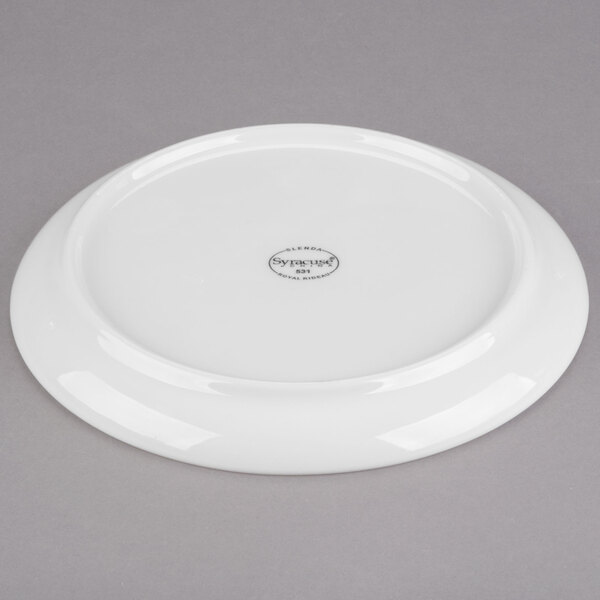 A white Libbey porcelain saucer with a circular design on it.