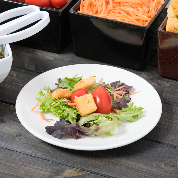 A Libbey white porcelain coupe plate with a salad, carrots, tomatoes, and croutons.