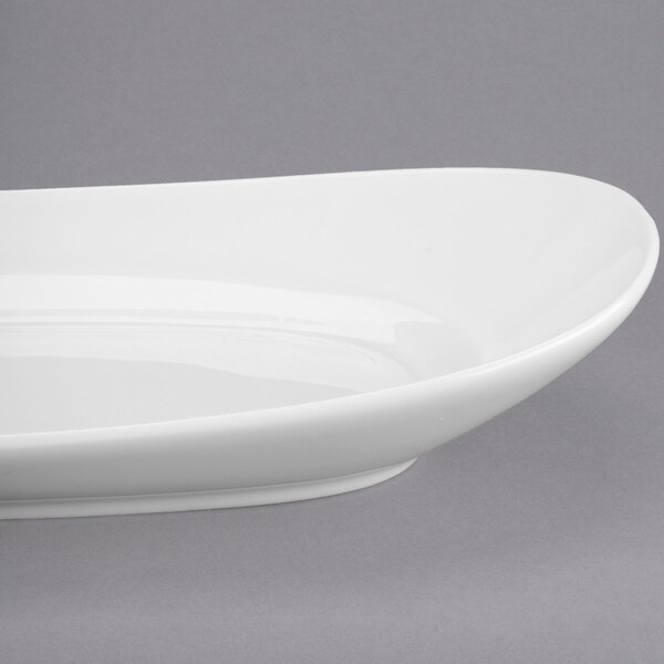 A white Libbey oval porcelain plate on a gray surface.