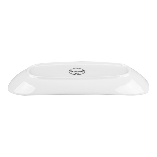 A white, oval-shaped porcelain plate with a slightly raised rim and a logo or stamp in the center.