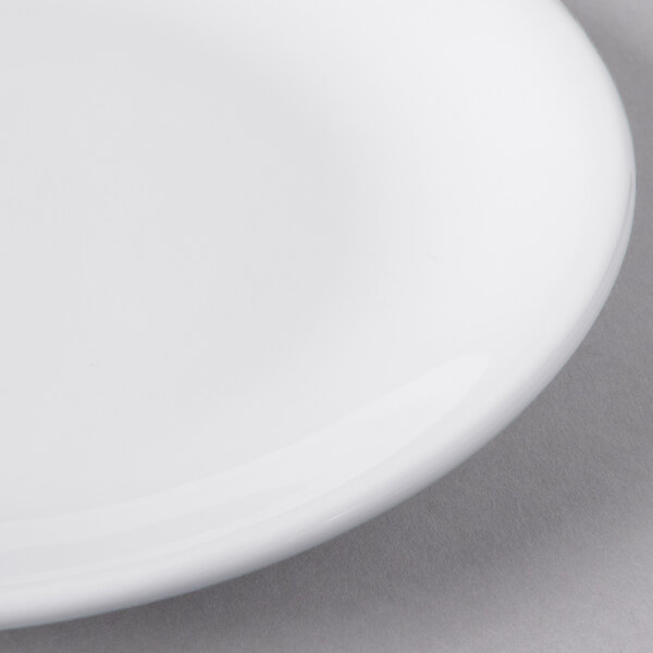 A close up of a Libbey white porcelain coupe plate with a white rim.