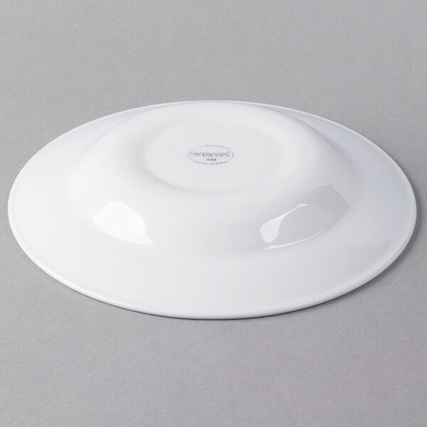 A Libbey white round porcelain entree and pasta bowl on a gray surface.