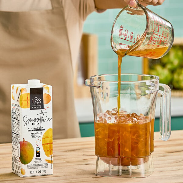 A woman pouring orange liquid into a blender.