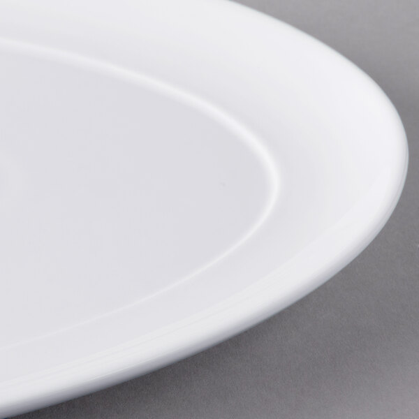 A close up of a Libbey Royal Rideau white porcelain tray with an oval rim.