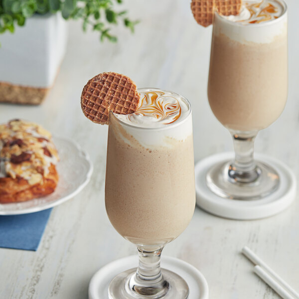 Two glasses of Cappuccine Supreme Caramel Latte Frappe Mix with a cookie on top.