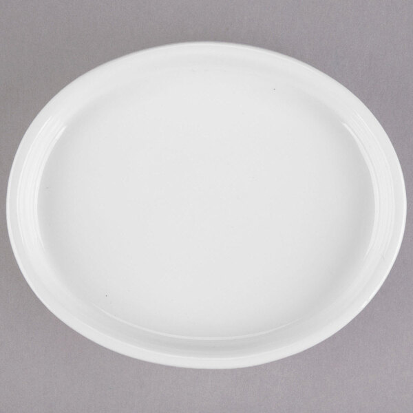 A white Libbey Slenda porcelain oval bowl on a gray surface.