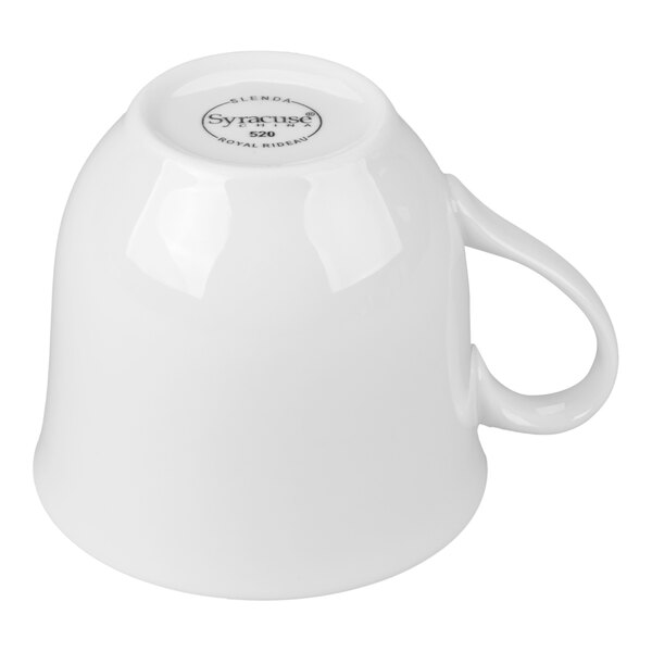 A white porcelain cup is shown upside down, displaying its handle and the manufacturer's mark on the bottom.