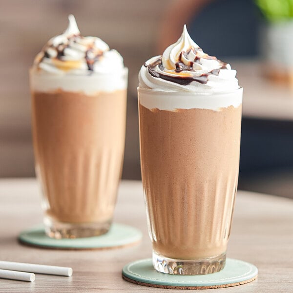 Two glasses of Cappuccine Kona Mocha Frappes with whipped cream on top.