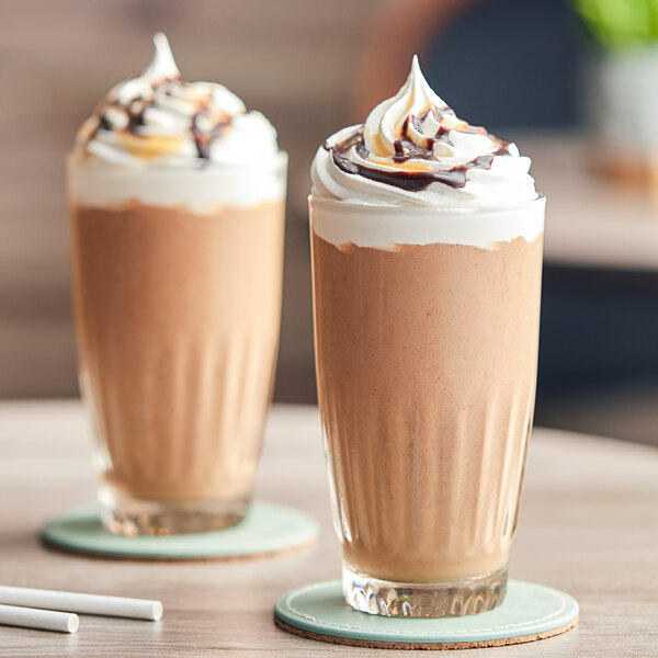 Two glasses of Cappuccine Supreme Kona Mocha Frappe with whipped cream on top.