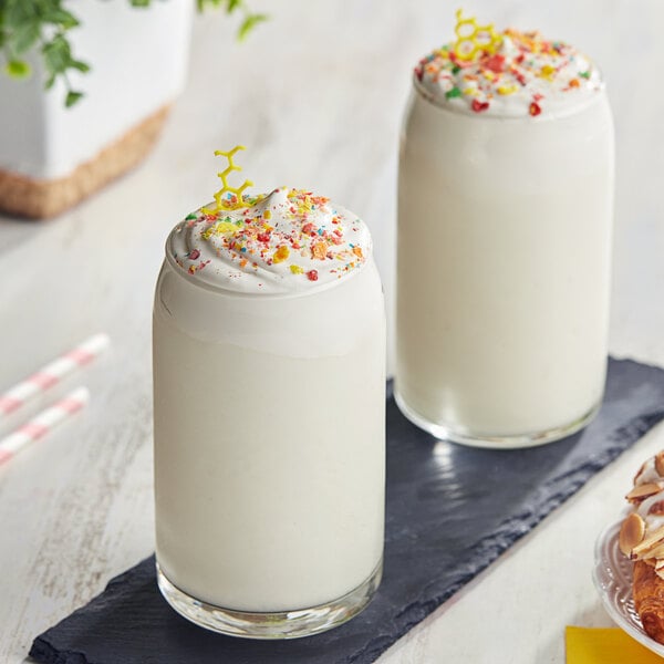 Two glasses of Cappuccine milkshakes with sprinkles on top.