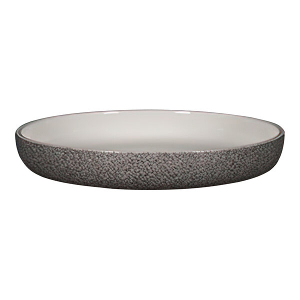 A RAK Porcelain white dual round deep porcelain plate with a black rim on a counter.