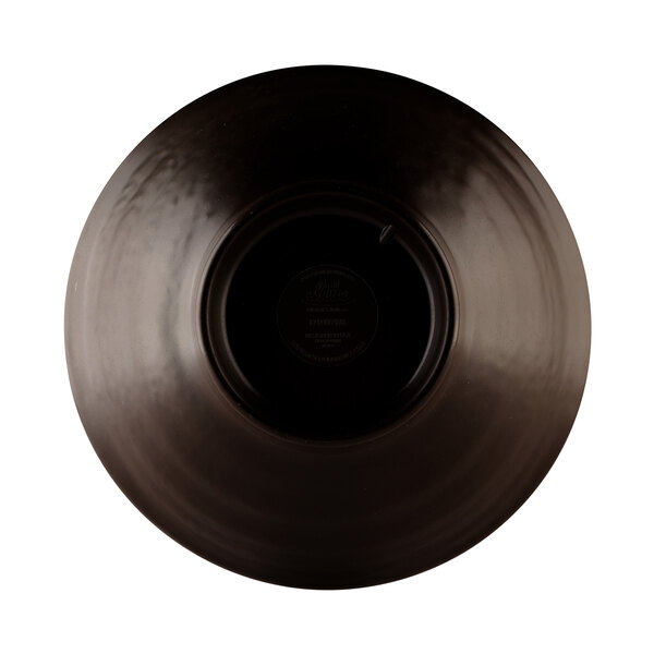 An olive oil-colored melamine bowl with a black pebble design in the middle.