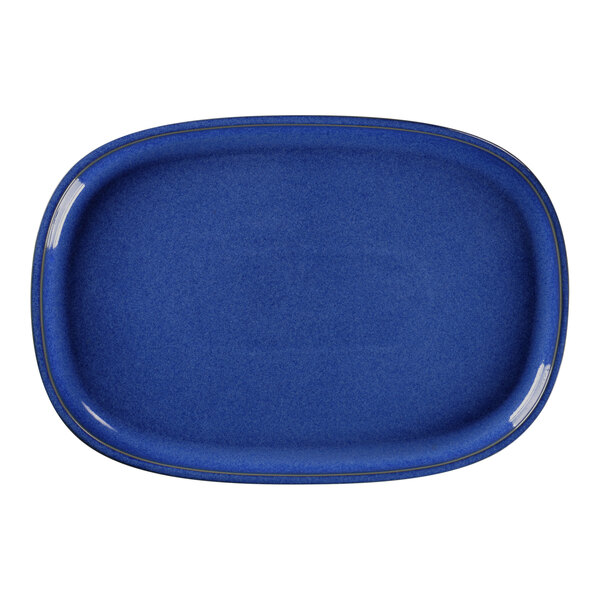 A blue oval porcelain plate with a rim on a table.