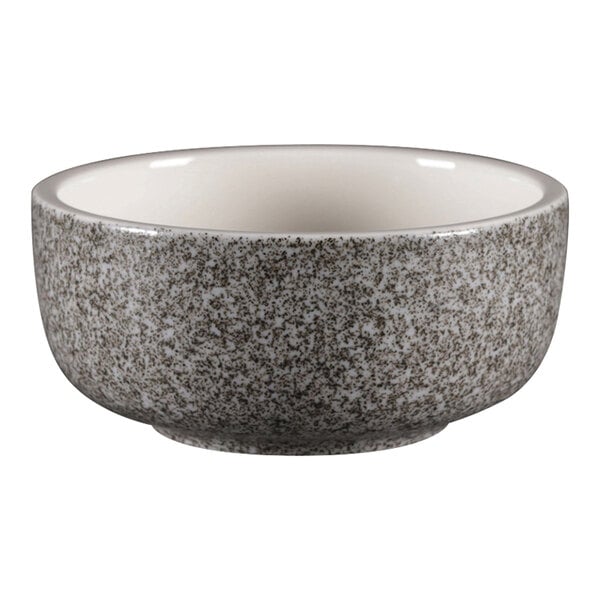 A close up of a white porcelain ramekin with a speckled design.