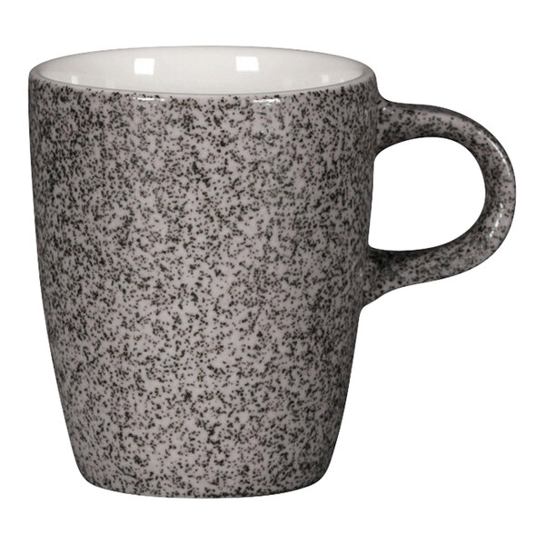 A white espresso cup with a speckled design and a white handle.