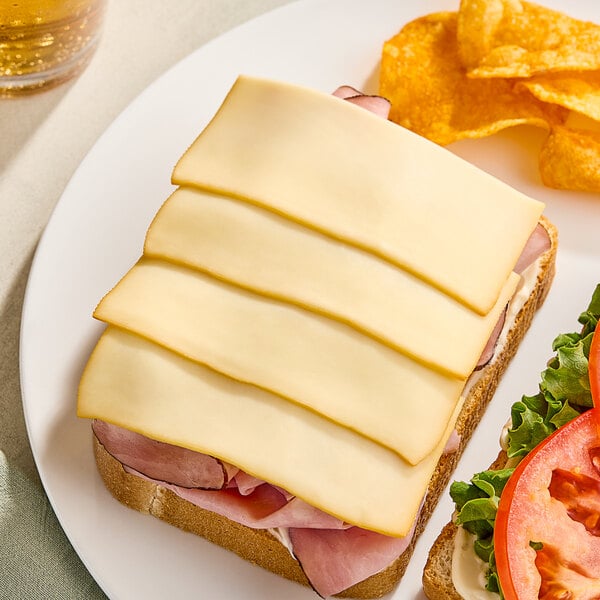 A sandwich with ham and Ammerlander Smoked Gouda cheese on a plate.