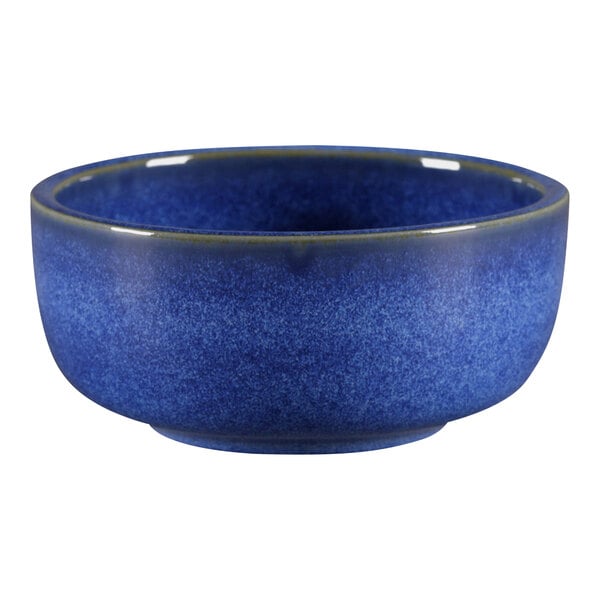 A blue porcelain ramekin with a green rim.