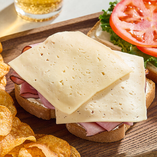 A sandwich with Ammerlander Havarti cheese and ham on a plate.