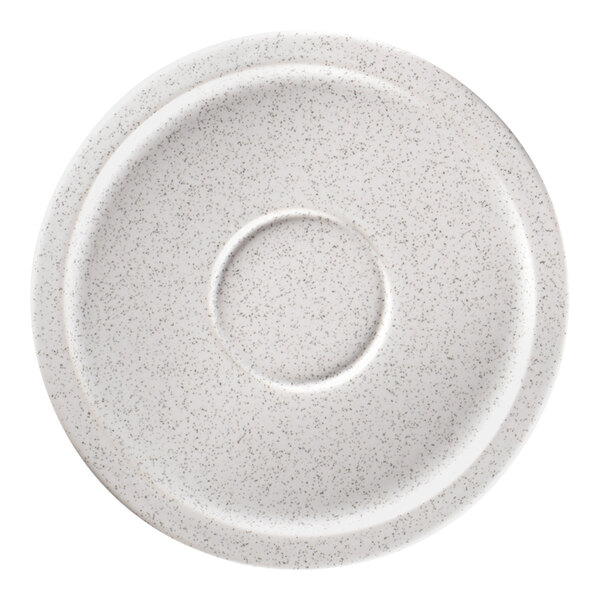 A white saucer with speckled specks and a white circle in the middle.
