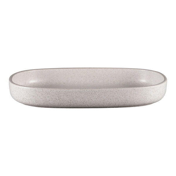 A white oval RAK Porcelain deep porcelain plate with speckled specks on a white counter.
