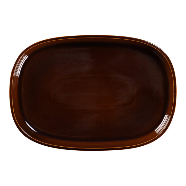 A brown oval porcelain plate with a white background.
